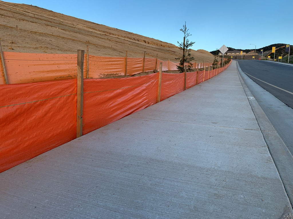 orange silt fence with stakes for slope erosion control