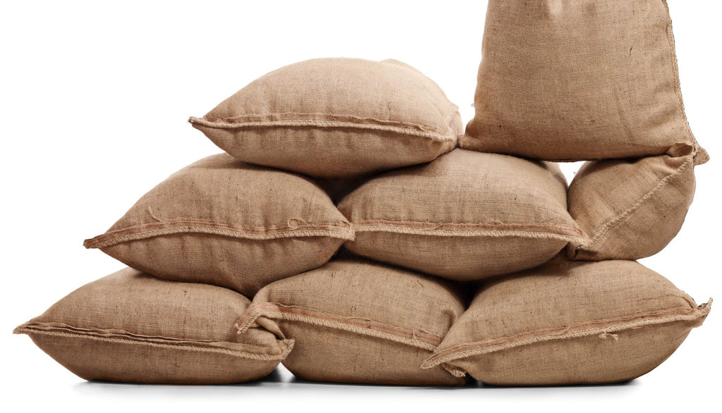Burlap bags filled and stacked on top of each other