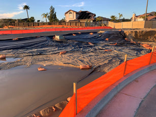 Orange woven geotextile fabric traps water laden sediment