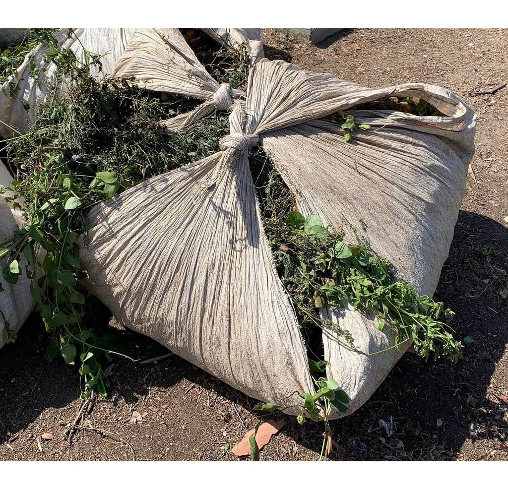 One 80x80 poly sheet bundle tied up and filled with leaves, branches, and twigs from landscaping