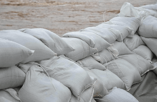 Use sandbags to prevent flooding by building a sandbag water barrier