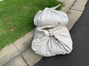 Two 80x80 white poly sheet  squares bundled and tied up after landscaping